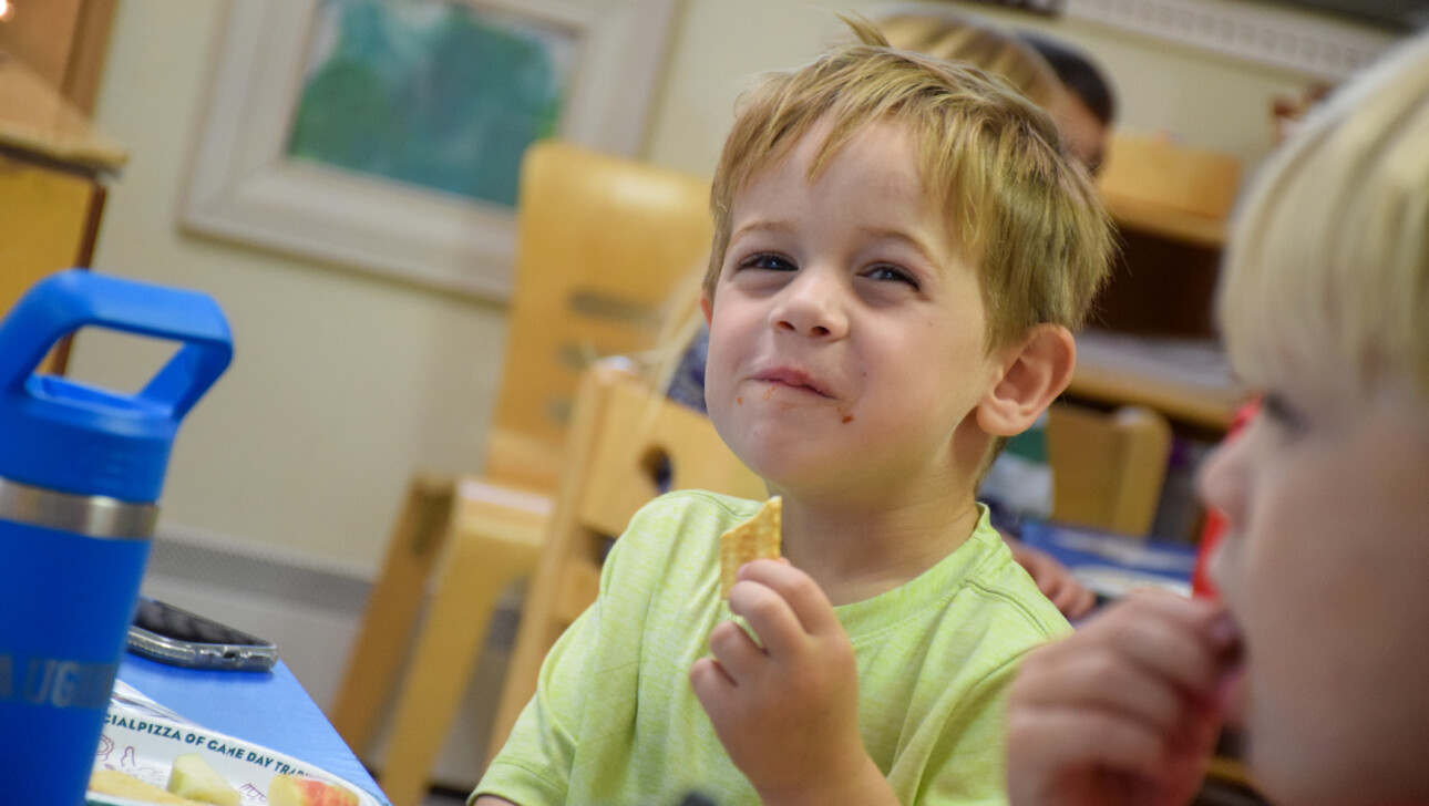 kid eating snack at Hingham Early Learning Center.