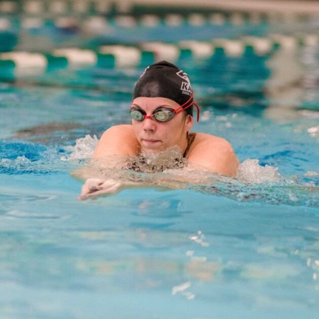 A person swimming in an indoor pool.