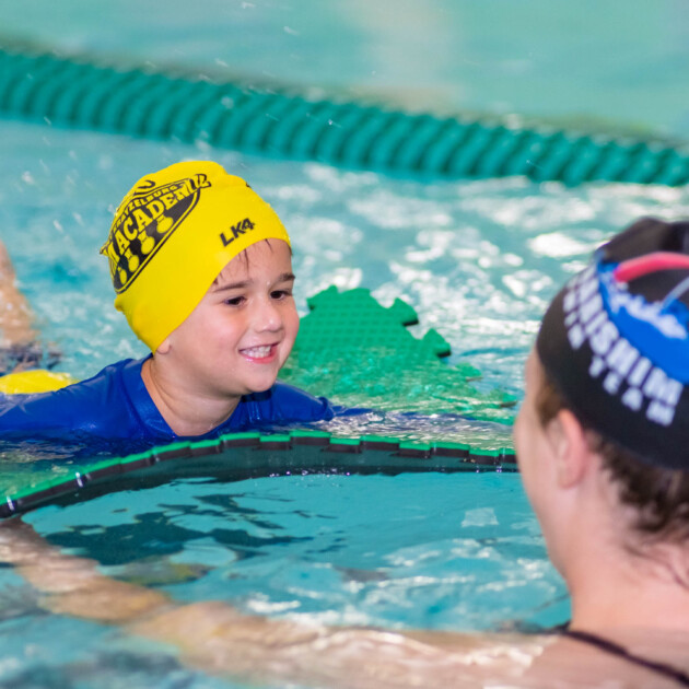 A young boy learning how to swim.