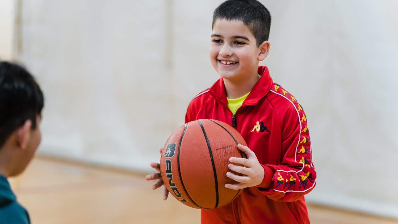 Boy smiling with a basketball.