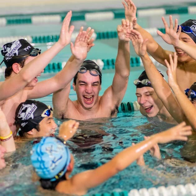 Group of teens cheering in the pool.