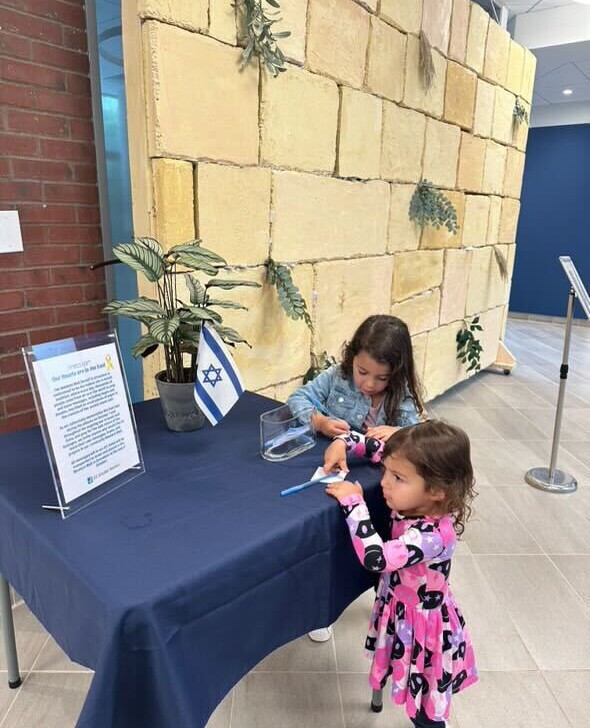 Kids adding notes to the Western Wall.